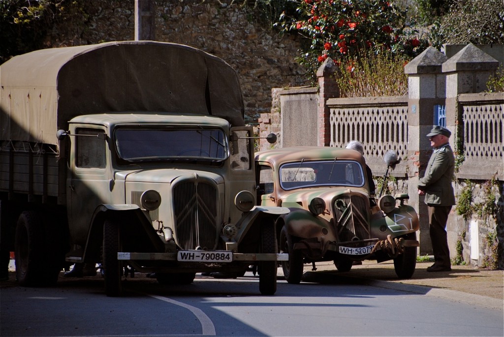 Installation des véhicules dans la rue : deux Citroën, un camion U23 et une Traction, toutes les deux en livrée militaire.