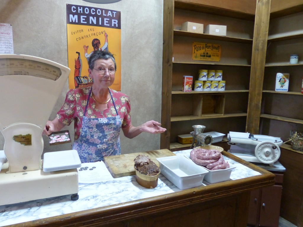 Dans le décor de la boutique, la vendeuse est bien réelle, ainsi que le pâté et les saucisses !