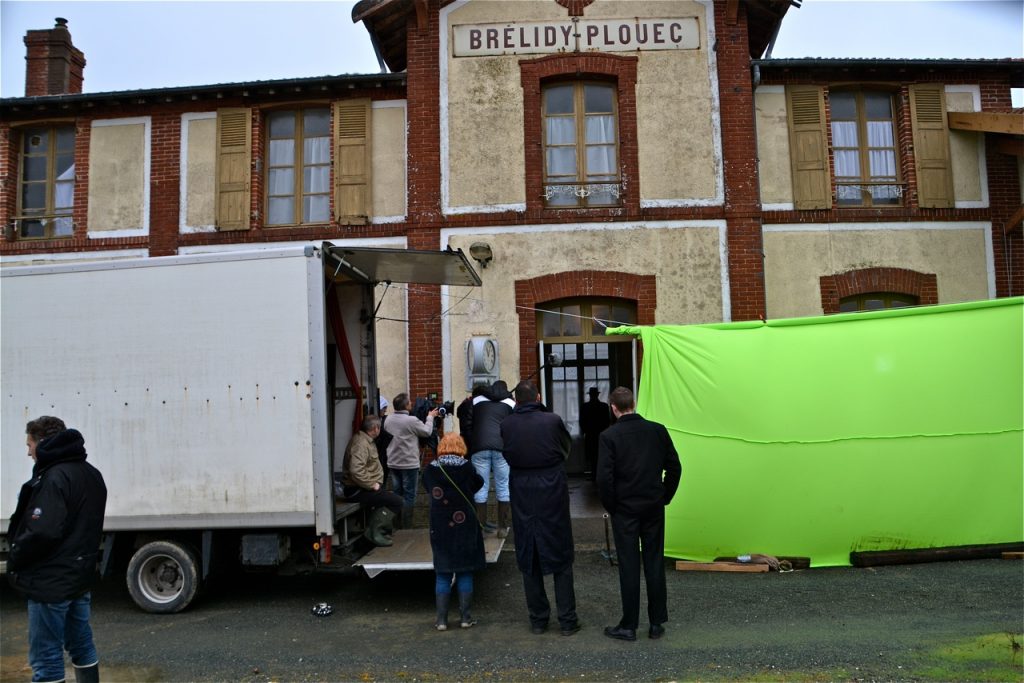Sous un temps maussade et pluvieux, installation de l'écran vert devant la façade de la gare.